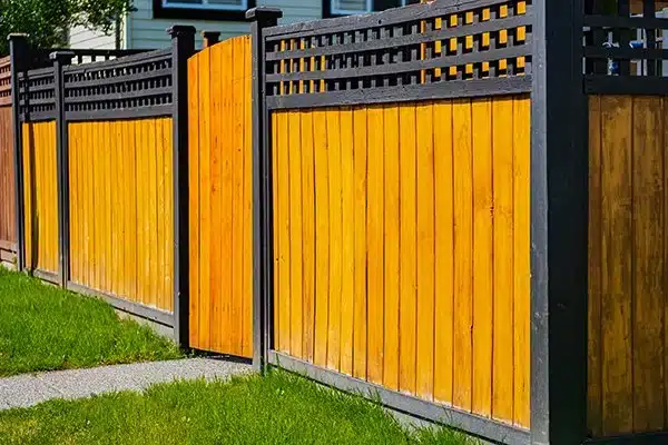 wooden fence with black trim in front of a home